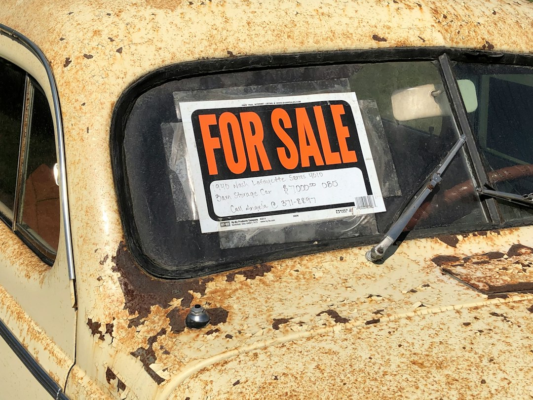 Carro antigo com placa de venda colada no vidro